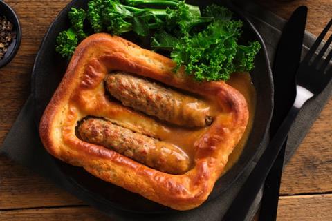 Vegan Toad in the Hole with kale on a black plate