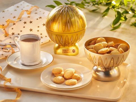 A Light Up Bauble Tin with a bowl of biscuits next to it and a cup of tea