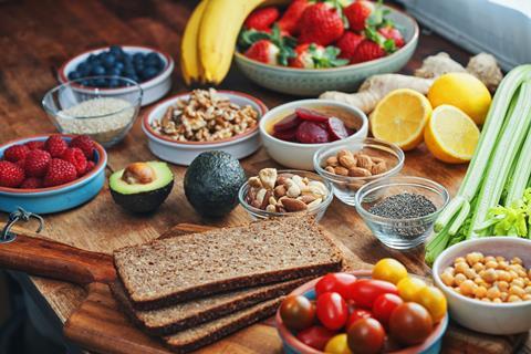A selection of healthy foods including rye bread, fruits, vegetables, and nuts