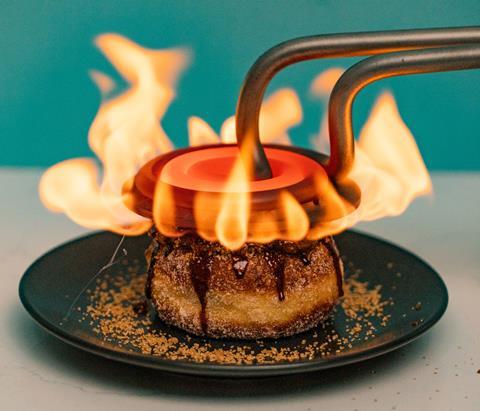 Bread Ahead Crème Brulee doughnut being torched with a heating element