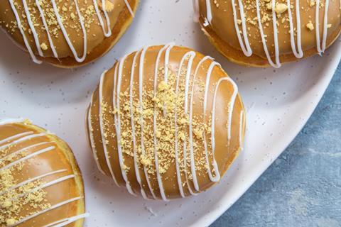 Salted caramel doughnuts with white icing drizzle and biscuit crumb on top