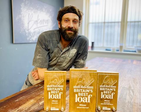Dan Booth covered in flour with three Britain's Best Loaf trophies