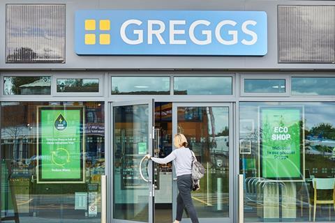 A woman walking into a Greggs eco shop