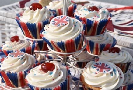 Cupcakes in Union Jack cases with white frosting and cherries on top