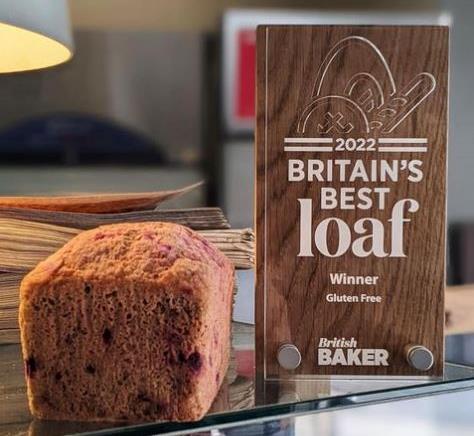 A smoked beetroot & chilli loaf next to a Britain's Best Loaf trophy