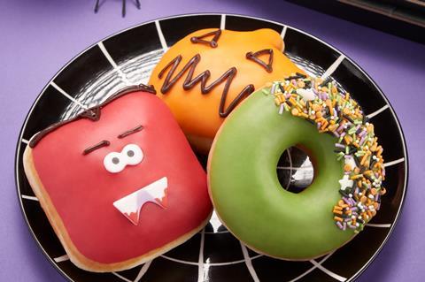Red, orange, and green Halloween doughnuts on a black spiderweb plate