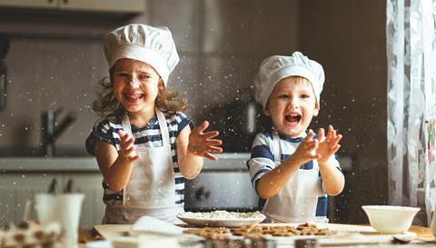 Two children baking biscuits at home