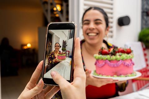 A person with a colourful cake on social media